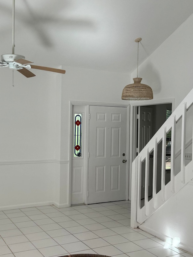 tiled foyer with ceiling fan and lofted ceiling