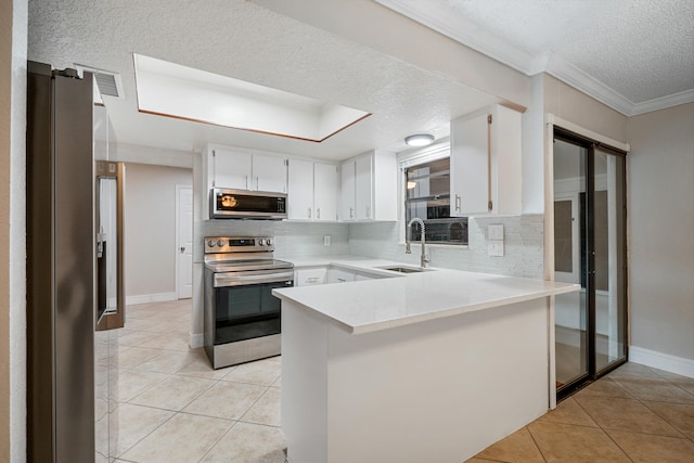 kitchen with stainless steel appliances, kitchen peninsula, a textured ceiling, decorative backsplash, and white cabinets