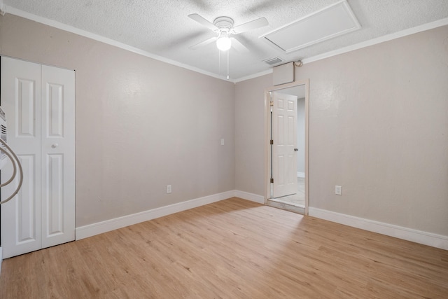 spare room with a textured ceiling, light hardwood / wood-style floors, ceiling fan, and ornamental molding