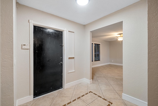 tiled entryway with ceiling fan