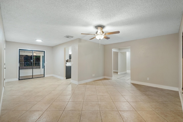 spare room with ceiling fan, light tile patterned floors, and a textured ceiling