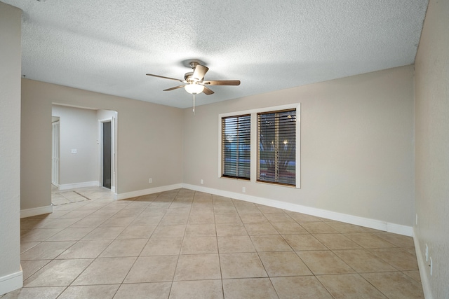 empty room with light tile patterned flooring and a textured ceiling