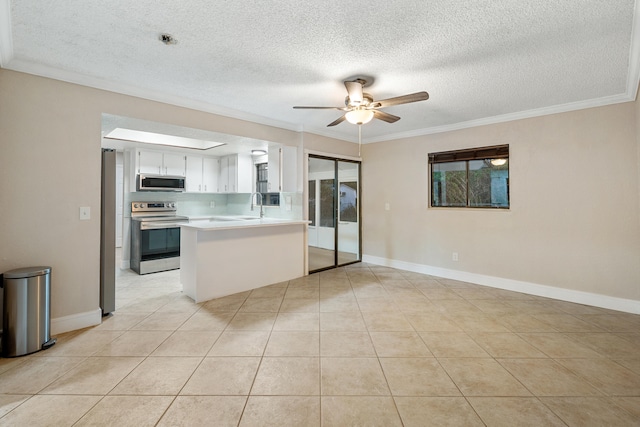 kitchen with kitchen peninsula, ornamental molding, stainless steel appliances, white cabinets, and light tile patterned flooring