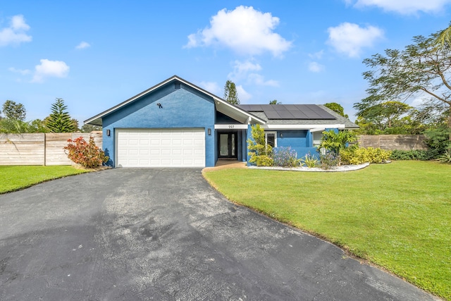 ranch-style house featuring solar panels, a garage, and a front lawn