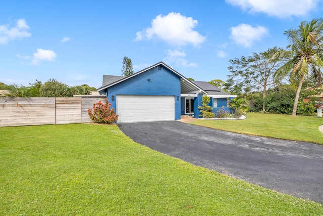 view of front of home featuring a front lawn, a garage, and solar panels