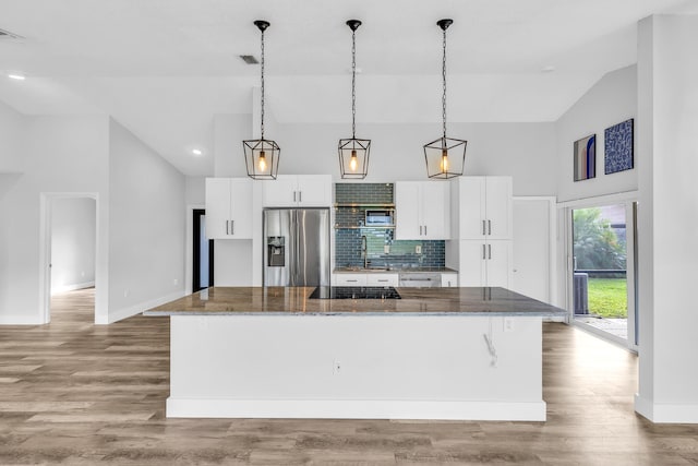 kitchen featuring white cabinets, a spacious island, light hardwood / wood-style flooring, dark stone countertops, and appliances with stainless steel finishes