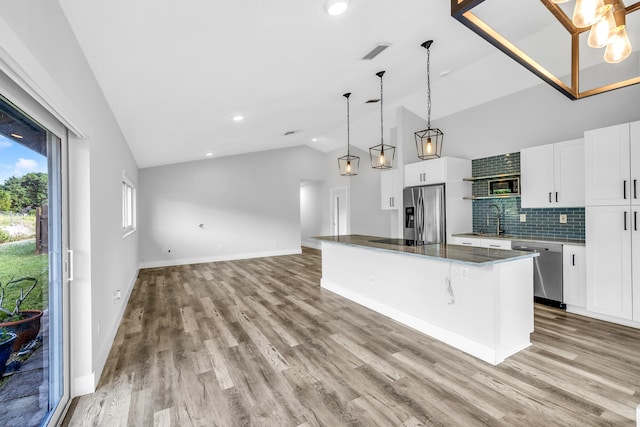 kitchen featuring a center island, hanging light fixtures, light wood-type flooring, white cabinetry, and stainless steel appliances