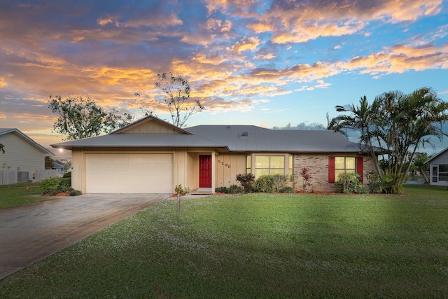 single story home featuring a yard and a garage