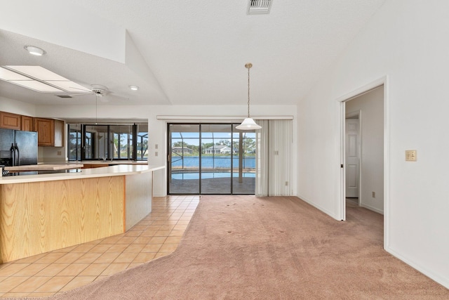 kitchen featuring pendant lighting, ceiling fan, light colored carpet, and lofted ceiling