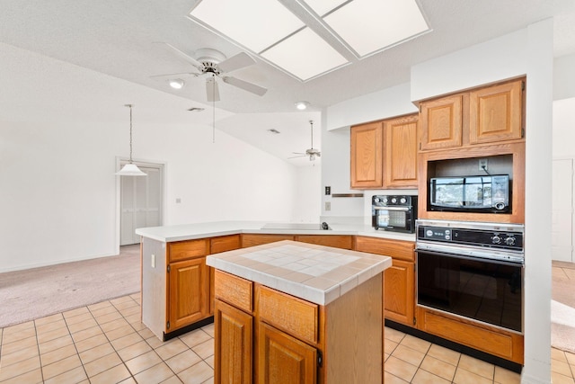 kitchen with light tile patterned floors, a kitchen island, lofted ceiling, and black appliances