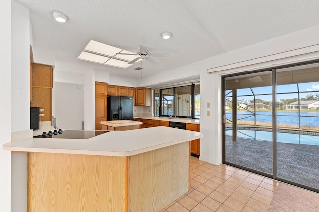 kitchen featuring black appliances, ceiling fan, kitchen peninsula, and a textured ceiling