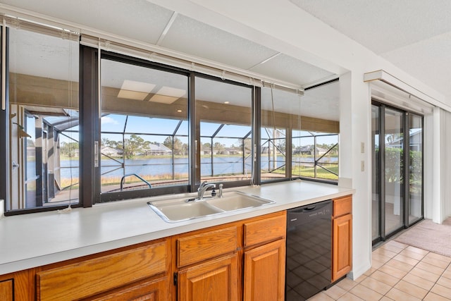 kitchen with dishwasher, light tile patterned flooring, a water view, and sink