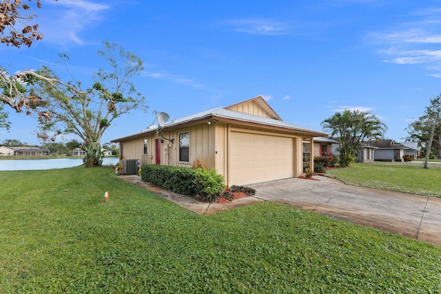 view of front of property with central air condition unit, a water view, a front yard, and a garage