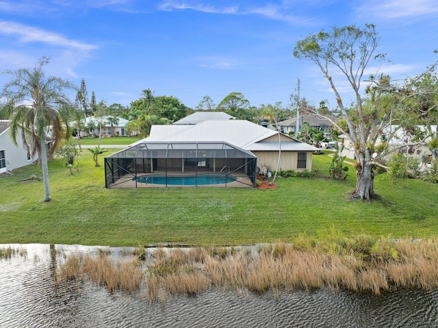 rear view of property with a water view, glass enclosure, and a lawn