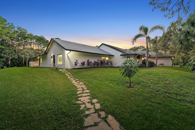 property exterior at dusk with a yard