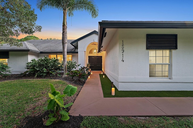 exterior entry at dusk with a yard