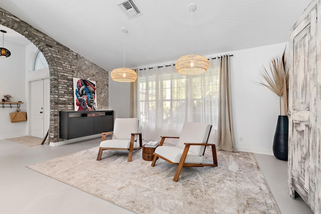 living area featuring vaulted ceiling and a notable chandelier