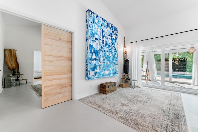 living room with lofted ceiling and concrete flooring