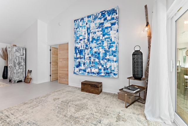 living room featuring vaulted ceiling and concrete floors