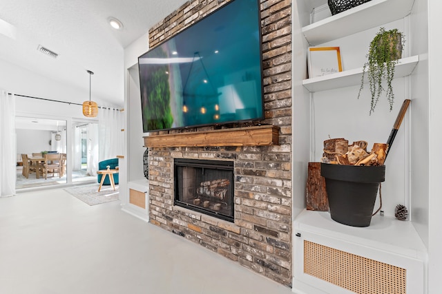 living room featuring vaulted ceiling, a textured ceiling, a fireplace, and concrete floors