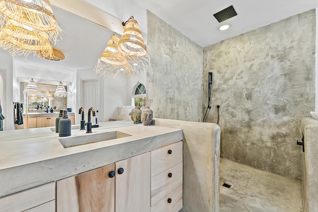 bathroom with tiled shower and vanity