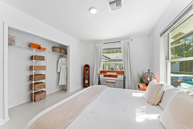 bedroom with a textured ceiling and a closet