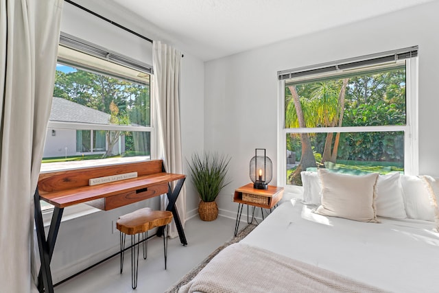 bedroom with multiple windows and concrete floors