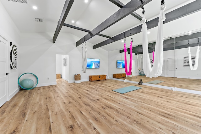 workout area featuring basketball court, light wood-type flooring, and lofted ceiling