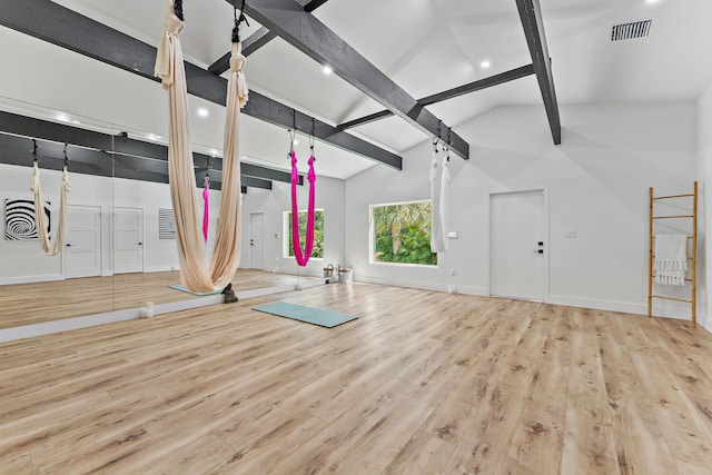 workout area with light hardwood / wood-style floors, vaulted ceiling, and basketball hoop