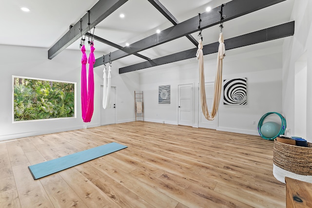 exercise area with hardwood / wood-style flooring and vaulted ceiling