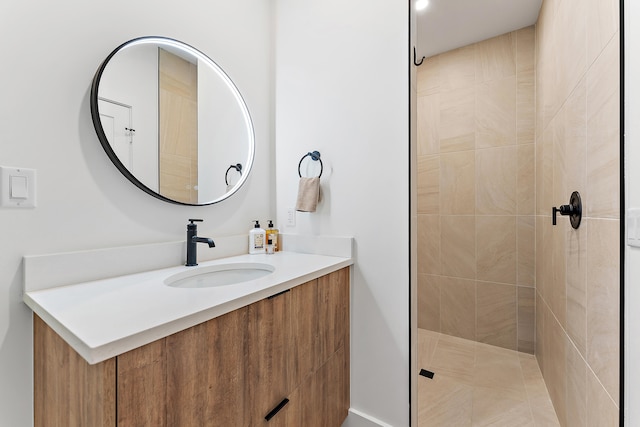 bathroom with vanity and a tile shower