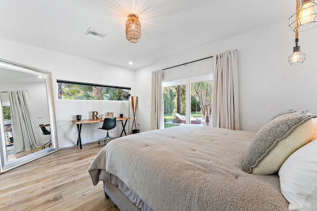 bedroom with wood-type flooring and access to exterior