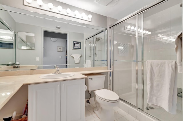 bathroom with toilet, vanity, tile patterned floors, and an enclosed shower