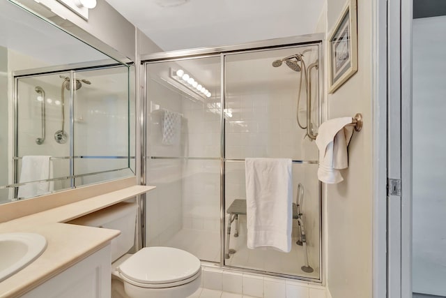 bathroom featuring tile patterned floors, vanity, toilet, and a shower with shower door