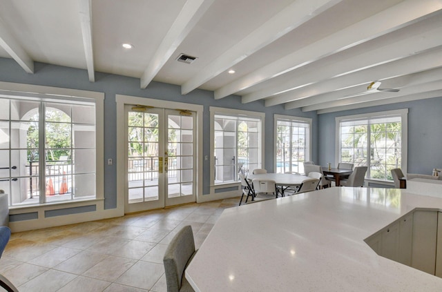 kitchen with french doors, ceiling fan, light stone countertops, light tile patterned floors, and beamed ceiling