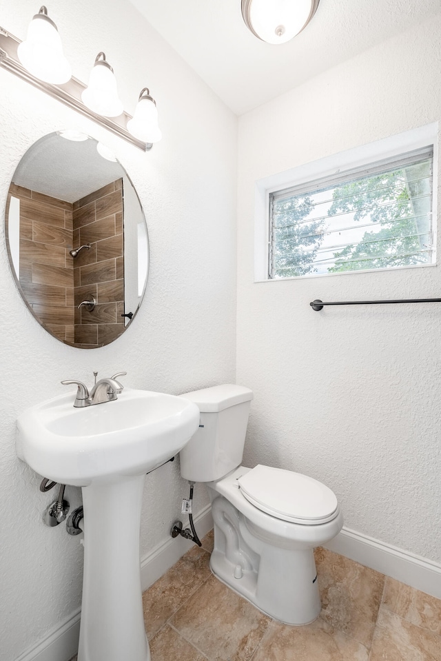 bathroom featuring tile patterned flooring, a shower, toilet, and sink