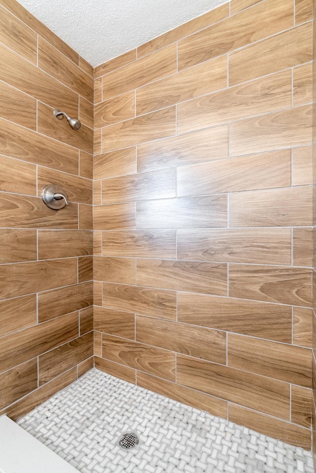 bathroom with a textured ceiling and walk in shower