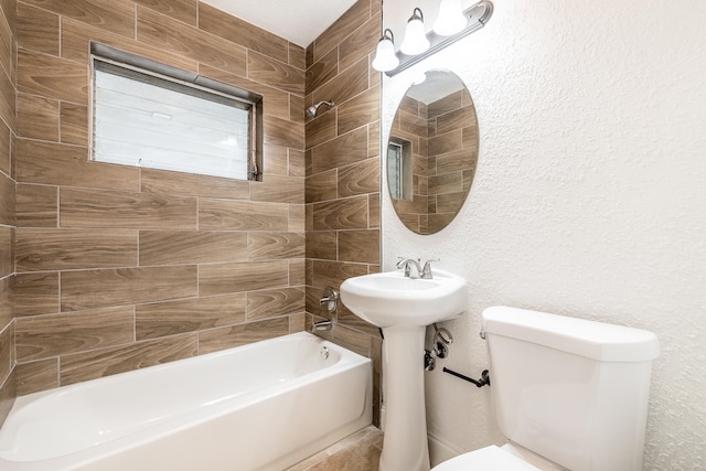 bathroom featuring tiled shower / bath combo and toilet