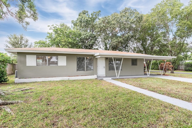 ranch-style house featuring a front lawn and a carport