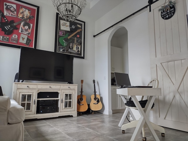 living room with a barn door and an inviting chandelier