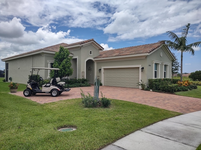 mediterranean / spanish-style home featuring a front yard and a garage