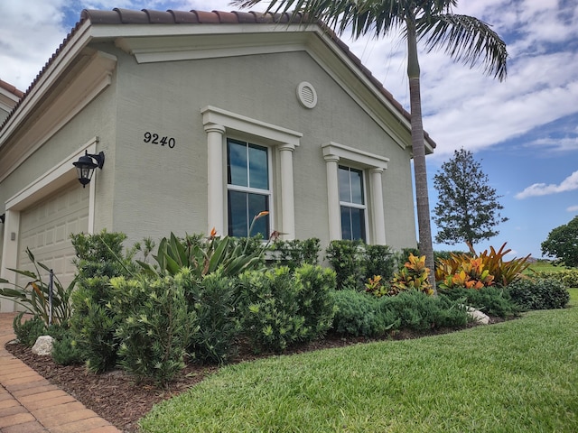 view of side of home featuring a garage and a yard