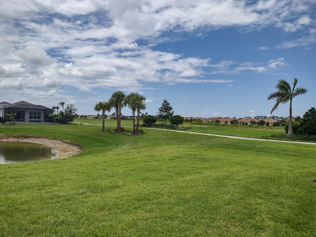 view of property's community featuring a lawn and a water view