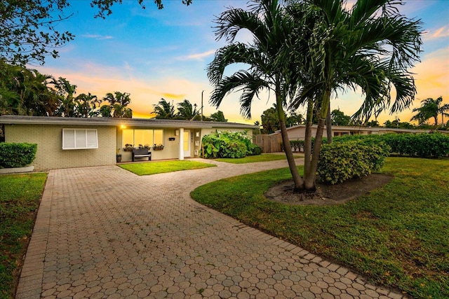 ranch-style home with a lawn