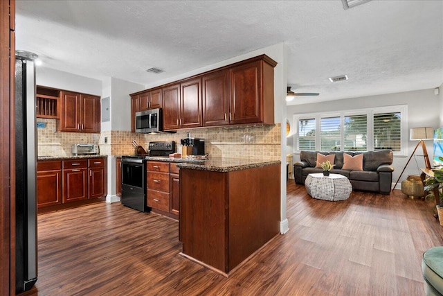 kitchen featuring backsplash, dark stone countertops, stainless steel appliances, and dark hardwood / wood-style floors