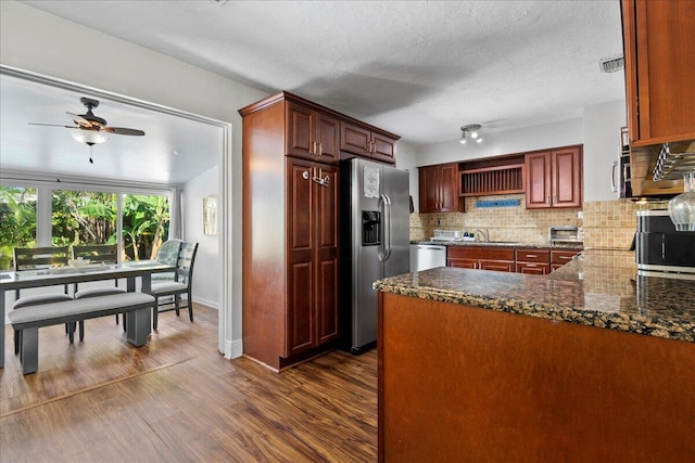 kitchen featuring sink, stainless steel appliances, dark hardwood / wood-style floors, backsplash, and kitchen peninsula