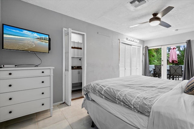 bedroom with ceiling fan, access to exterior, a textured ceiling, and a closet