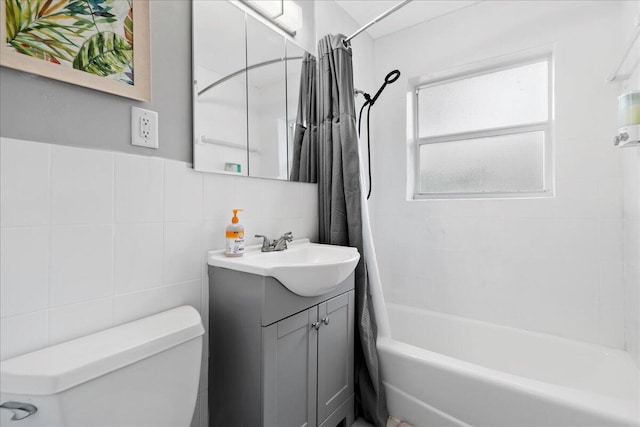 full bathroom featuring shower / bath combo, tasteful backsplash, toilet, vanity, and tile walls