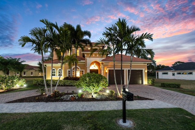 mediterranean / spanish-style home featuring a yard and a garage