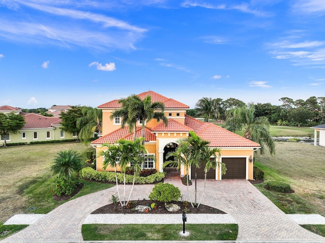 mediterranean / spanish house with a garage and a front lawn